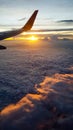 Wing of Jet plane fly over the sunset sky above cloud Royalty Free Stock Photo