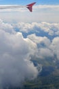 Wing of plane above cloudy sky in sunny day. Concept of travel, freedom, dreams, transport, eternity, hope. View from airplane