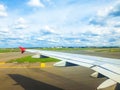 Wing of plane in Amsterdam airport. Airplane is on runway. The plane takes off or landing. Royalty Free Stock Photo