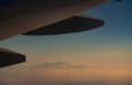 Wing of plane over blurred mountain cover with white snow. Airplane flying. Scenic view from airplane window. Commercial airline Royalty Free Stock Photo