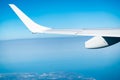 Wing of plane over the city and land. Airplane flying on blue sky. Scenic view from airplane window. Commercial airline flight. Royalty Free Stock Photo