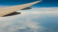 Wing of plane over mountain cover with fog and mist. Airplane flying on blue sky. Scenic view from airplane window. Commercial air Royalty Free Stock Photo