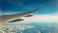 Wing of plane over mountain cover with white snow. Airplane flying on blue sky. Scenic view from airplane window. Commercial Royalty Free Stock Photo