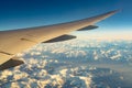 Wing of plane over mountain cover with white snow. Airplane flying on blue sky. Scenic view from airplane window. Commercial Royalty Free Stock Photo