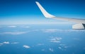 Wing of plane over white clouds. Airplane flying on blue sky. Scenic view from airplane window. Commercial airline flight. Plane Royalty Free Stock Photo