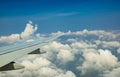 Wing of plane over white clouds. Airplane flying on blue sky. Scenic view from airplane window. Commercial airline flight. Plane Royalty Free Stock Photo