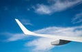 Wing of plane over white clouds. Airplane flying on blue sky. Scenic view from airplane window. Commercial airline flight. Plane Royalty Free Stock Photo