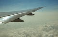 Wing of plane over white clouds. Airplane flying on blue sky. Scenic view from airplane window. Commercial airline flight. Plane Royalty Free Stock Photo