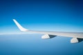 Wing of plane over white clouds. Airplane flying on blue sky. Scenic view from airplane window. Commercial airline flight. Plane Royalty Free Stock Photo