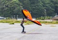 Wing Surfer, man on skateboard flying a wing, foil wing, sky wing, riding the wind with a wing on a skateboard Royalty Free Stock Photo