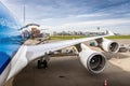 Wing view of a large jet airplane. Boeing 747 loading cargo via rear door.