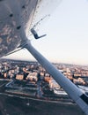 Wing view of a small plane taking off the airport runway at sunset over the city Royalty Free Stock Photo