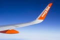 The wing and winglets of an Airbus A320 commercial airliner with a company logo while in flight