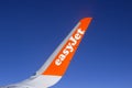 The wing and winglets of an Airbus A320 commercial airliner with a company logo while in flight