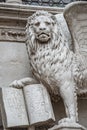 Winged lion with a Bible and a priest at Basilica San Marco in Venice, Italy, summer time, details, closeup Royalty Free Stock Photo