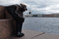 Winged lion on a cloudy spring day at the university embankment. Egyptian griffin on the background of the Neva River and St. Isaa