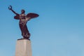 Winged victory statue. Monument to the war dead of the first world war. Winged angel with laurel in hand. Cloudless blue sky in