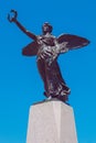 Winged victory statue. Monument to the war dead of the first world war. Winged angel with laurel in hand. Cloudless blue sky in