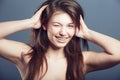 Wink, face and beauty portrait of a woman in studio with a smile, makeup and hands in hair. Headshot of a happy female