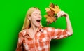 Winking blonde woman with maple leaves. Autumn clothes. Smiling girl playing with leafs.