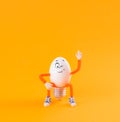 Winking Easter egg toy in the shape of a light bulb on a yellow Royalty Free Stock Photo