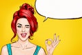 Winking girl is showing OK sign with speech bubble. Pop Art girl. Party invitation. Birthday greeting card. Hollywood movie star. Royalty Free Stock Photo