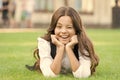 Winking to you. School break for rest. Adorable pupil. Girl kid laying lawn. Girl school uniform enjoy relax. Importance