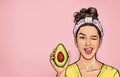 Winking woman get beauty treatments, holding avocado. Optimistic smiling young girl.