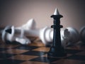 Winner. A black king surrounded by white chess pieces in a chess board game competition with copy space on a dark background. Royalty Free Stock Photo