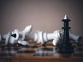 Winner. A black king surrounded by white chess pieces in a chess board game competition with copy space on a dark background. Royalty Free Stock Photo