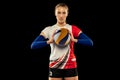 Portrait of beautiful woman, professional volleyball player posing with ball isolated on dark background. Sport, healthy Royalty Free Stock Photo