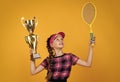 winner child with racquet and champions cup. teen girl win tennis championship. sport. tennis or badminton player