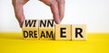 Winner or dreamer symbol. Concept words Winner or dreamer on wooden cubes. Businessman hand. Beautiful yellow table white