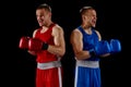 Winner emotions. Two twins brothers, professional boxers in blue and red sportswear isolated on dark background. Concept Royalty Free Stock Photo