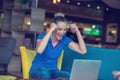 Winner girl euphoric watching a laptop in a coffee shop wearing a blue shirt Royalty Free Stock Photo