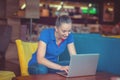 Winner girl euphoric watching a laptop in a coffee shop wearing a blue shirt Royalty Free Stock Photo