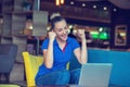 Winner girl euphoric watching a laptop in a coffee shop wearing a blue shirt Royalty Free Stock Photo