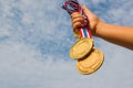 Winner hand raised and holding two gold medals with Thai ribbon Royalty Free Stock Photo