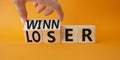 Winner and Loser symbol. Businessman hand turnes wooden cubes and changes word Looser to Winner. Beautiful orange background.