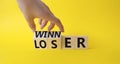 Winner and Loser symbol. Businessman hand turnes wooden cubes and changes word Looser to Winner. Beautiful yellow background.