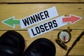 Winner or Losers opposite direction signs with boots, eyeglasses and compass on wooden Royalty Free Stock Photo