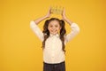 Winner revealed Happy little prize winner putting crown jewel on head on yellow background. Adorable school award winner