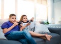 Winner takes all. two young children sitting on a sofa and playing video game at home. Royalty Free Stock Photo