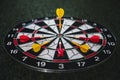 Winner yellow dart arrow hit center target of dartboard and other arrow loser metaphor marketing competition concept, on dark Royalty Free Stock Photo