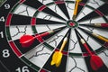 Winner yellow dart arrow hit center target of dartboard and other arrow loser metaphor marketing competition concept, on dark Royalty Free Stock Photo