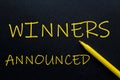 Winners Announced Yellow Pen with yellow text own rent at the black background