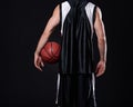 Winners never quit and quitters never win. Cropped rearview of a basketball player holding a basketball against a black