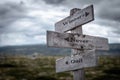 Winners never quit text on wooden rustic signpost outdoors in nature/mountain scenery.