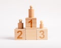Winners podium from wooden blocks with knobbed cylinders and numbers 1, 2, 3. Hierarchy, ranking concept. Distribution Royalty Free Stock Photo