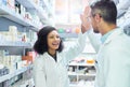 Winners in the wellness industry. a mature man and young woman giving each other a high five while working in a pharmacy Royalty Free Stock Photo